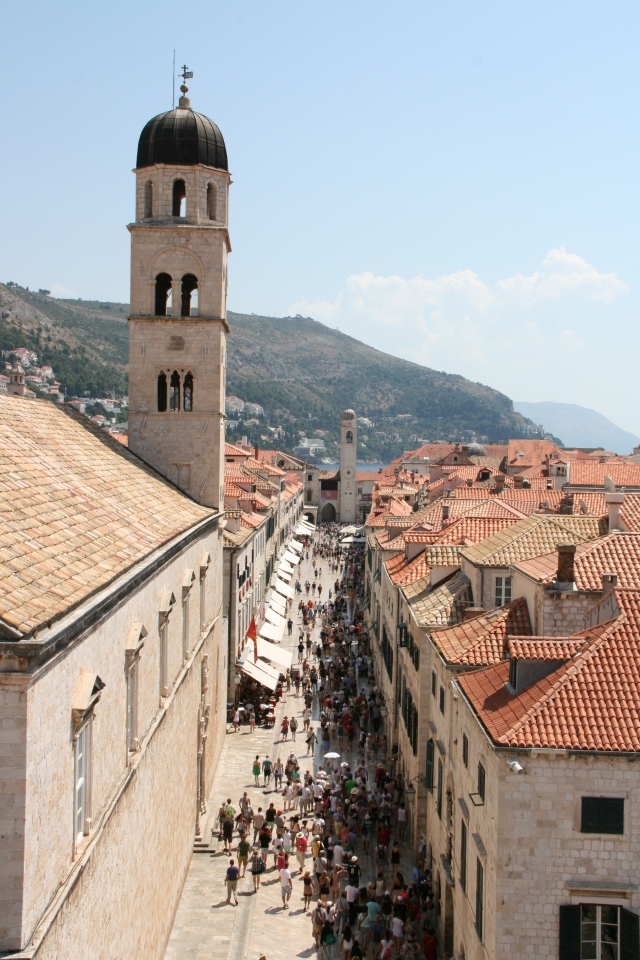 Crowds of tourists walking through the main street of the old city.